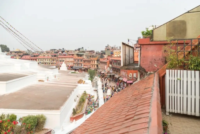 View from the balcony of the Hotel Padma Stupa View Suite, featuring people strolling around the Stupa.